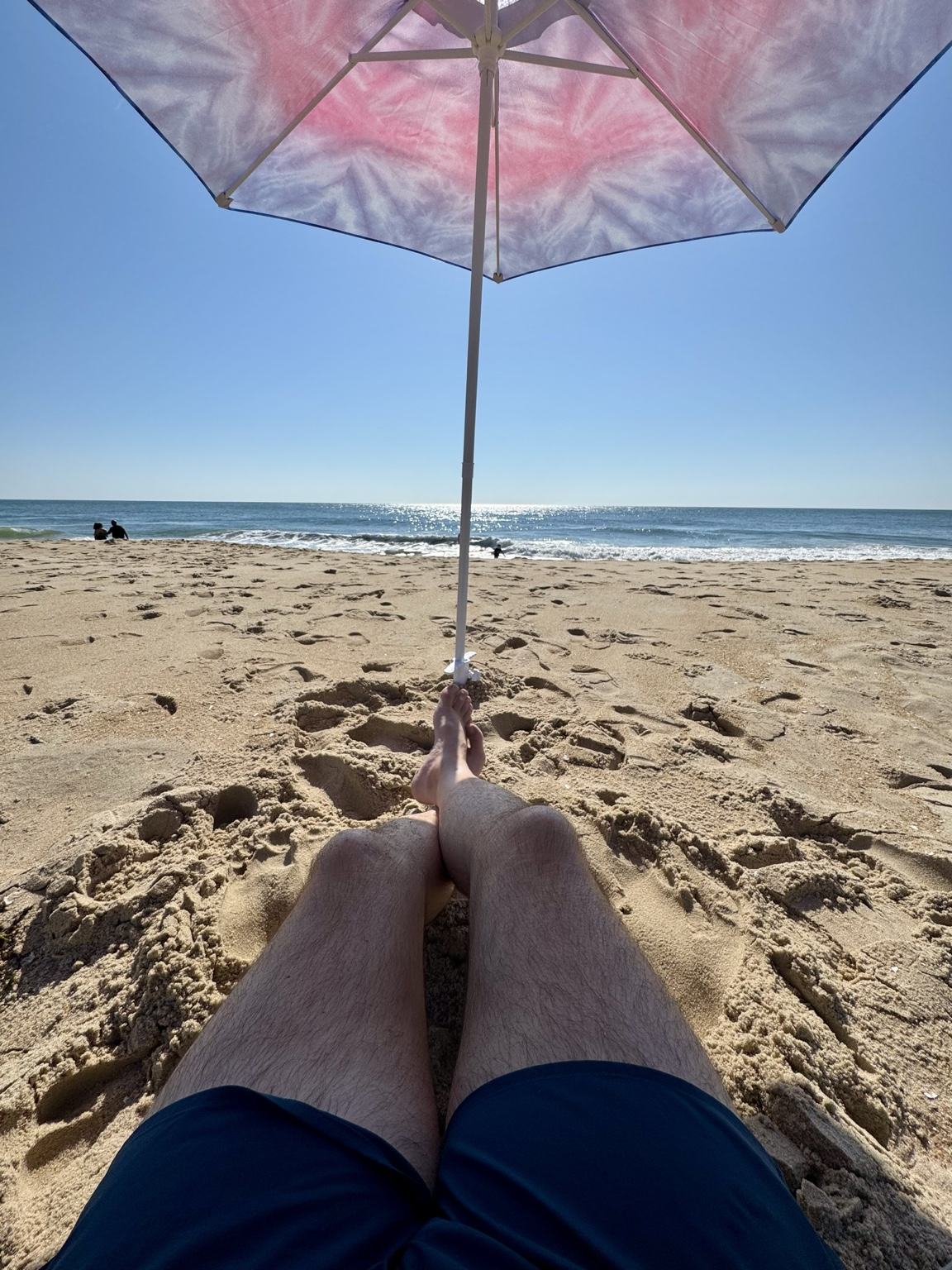 View of the ocean from under a beach umbrella